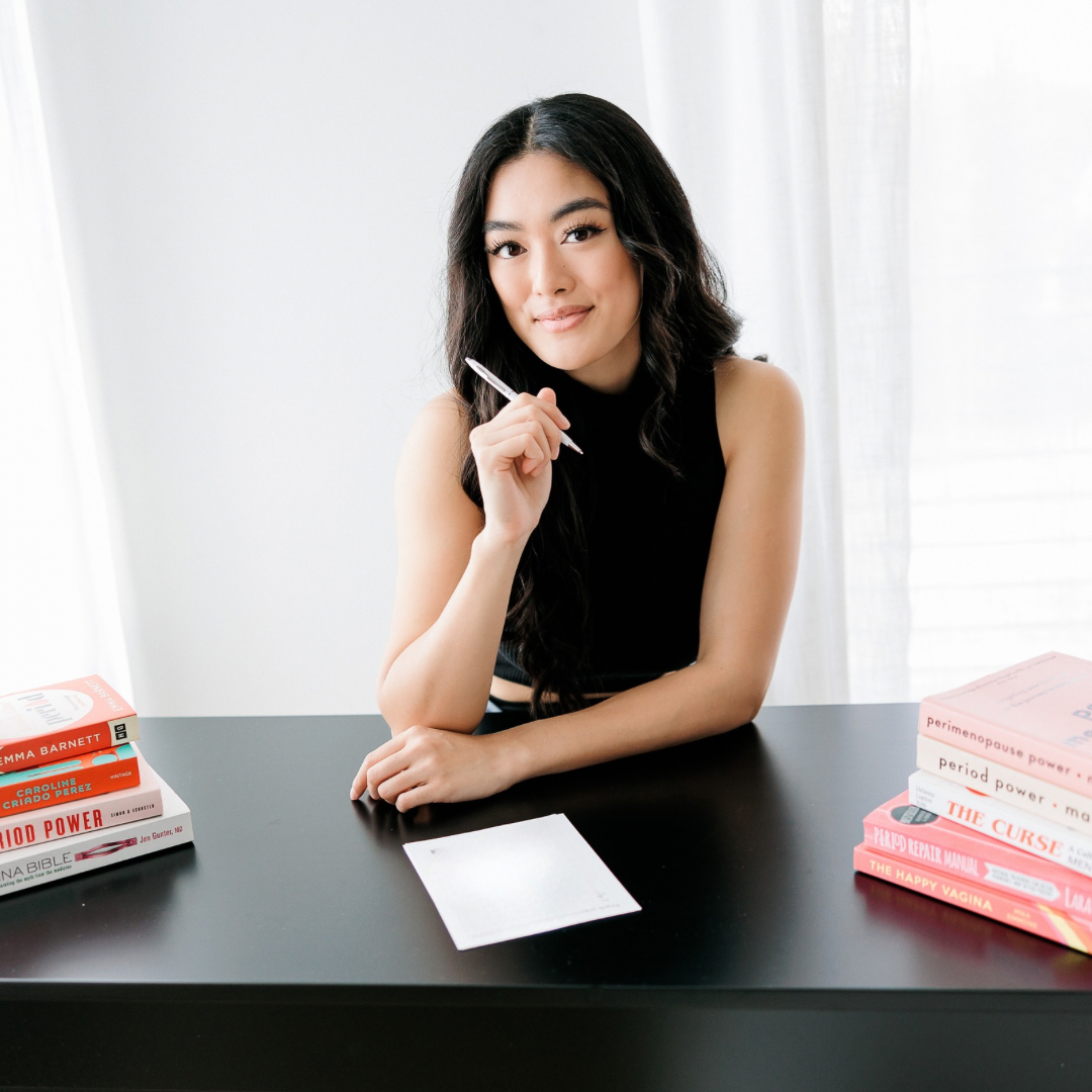 Woman sitting at desk filling out a period tracker