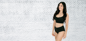 Woman standing slightly sideways wearing Fri Period underwear and smiling.