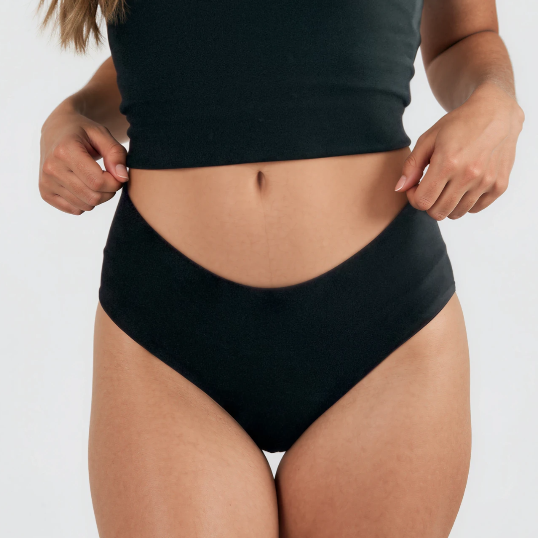 Person wearing black Fri Period low-rise hipsters on a plain background