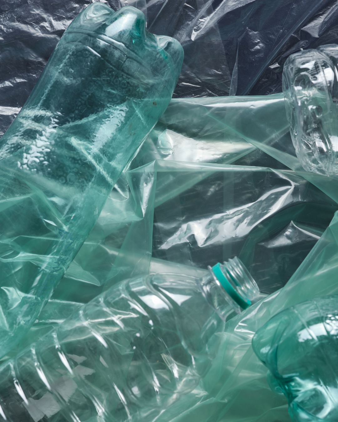 Stack of green plastic bottles on a black background